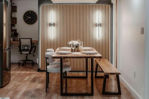 a dining room with a table and chairs and a clock at The Barrie Nook in Barrie