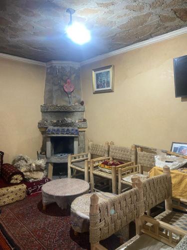 a living room with a room with a fireplace at Maison d'hôtes Moussem des fiançailles in Imilchil
