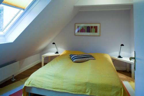 a bedroom with a bed in a attic with two lamps at Altstadtflair Apartment in Husum