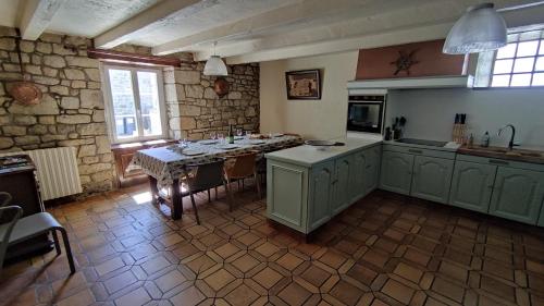 une cuisine avec une table et un astérisque d'astryastryastryasteryasteryasteryastery dans l'établissement Gîte Ty Maen à Plouhinec 56 4pers, à Plouhinec