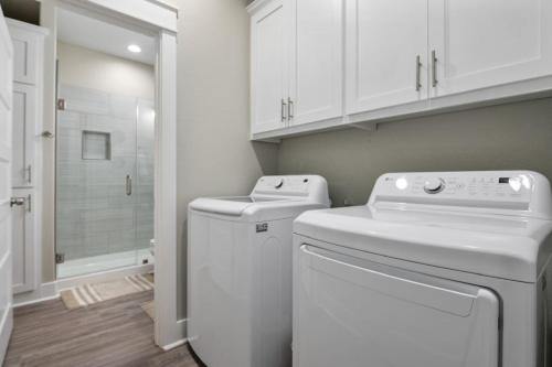 a white laundry room with a washer and dryer at Two Adjacent Cabins, Sleeps 18 in Bolivar Peninsula