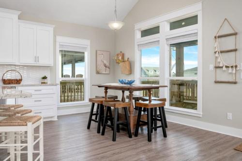 a kitchen with a table and chairs in a room at Two Adjacent Cabins, Sleeps 18 in Bolivar Peninsula