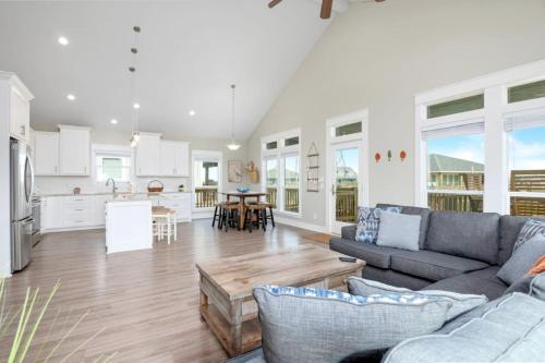 a living room with a couch and a kitchen at Two Adjacent Cabins, Sleeps 18 in Bolivar Peninsula