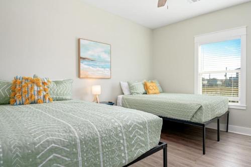 a bedroom with two beds and a couch at Two Adjacent Cabins, Sleeps 18 in Bolivar Peninsula