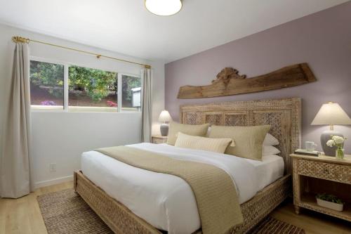 a bedroom with a large bed and a window at Private Garden and Tranquil Haven in Summerland