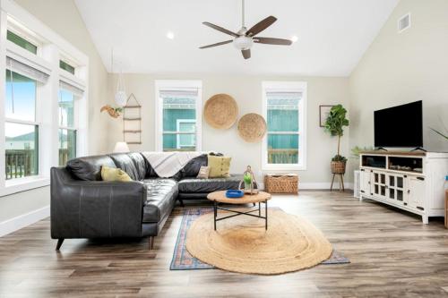 a living room with a couch and a tv at Two Adjacent Cabins, Sleeps 18 in Bolivar Peninsula