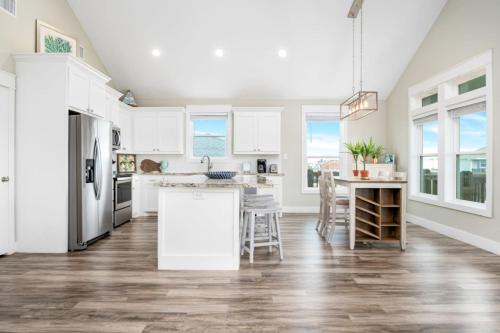 a kitchen with white cabinets and a table and chairs at Two Adjacent Cabins, Sleeps 18 in Bolivar Peninsula