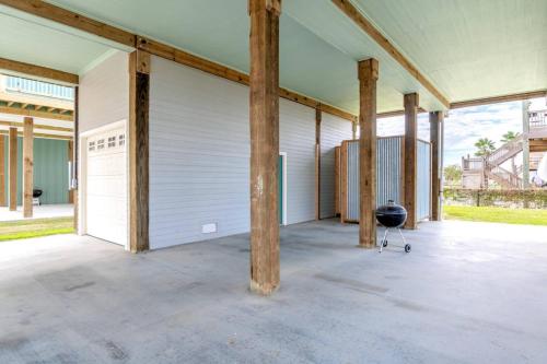 an empty patio with wooden poles and a grill at Two Adjacent Cabins, Sleeps 18 in Bolivar Peninsula