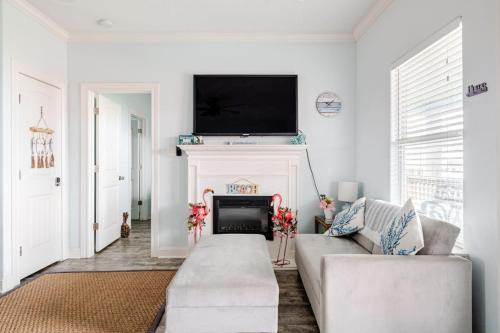 a living room with a couch and a tv over a fireplace at Gulf View 3BR 2BA Steps to Beach 2 King Beds in Bolivar Peninsula