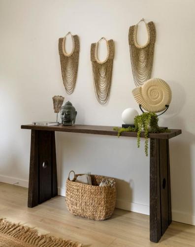 a wooden console table with baskets on the wall at Private Balcony and Coastal Escape in Summerland
