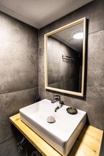 a bathroom with a white sink and a mirror at Rock Solid Stone House - Chora Samothraki in Samothraki