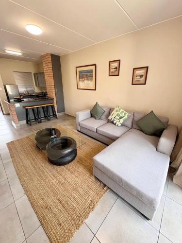 a living room with a couch and a table at The Place at Mall of Africa 2 in Midrand