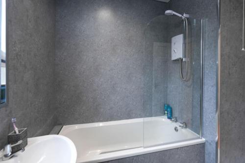 a bathroom with a shower and a tub and a sink at Barassie Villa located near Troon in Troon
