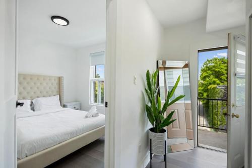 a white bedroom with a bed and a mirror at Luxurious 4BR with Sunny Deck Balcony in Montréal