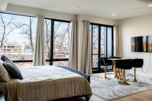 a bedroom with a bed and a desk and windows at Chic Luxury 4BR Townhome with NYC Views in North Bergen