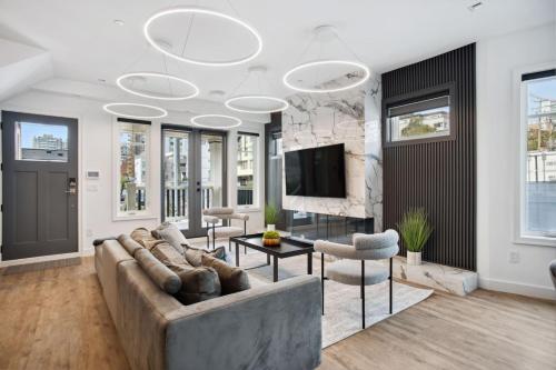 a living room with a couch and a tv at Luxury Downtown Vancouver Home Near Sunset Beach with Parking in Vancouver