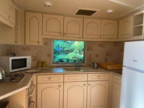 a kitchen with white cabinets and a sink and a window at Domek wakacyjny in Sumowo