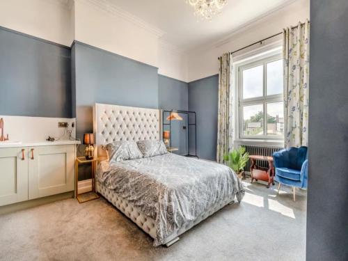 a bedroom with a bed and a blue wall at Riverside Georgian House with Hot Tub, Sauna & Parking in Selby