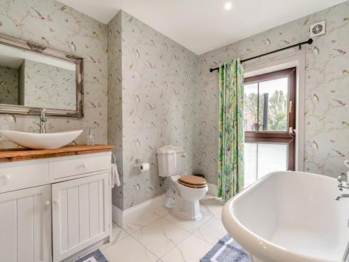 a bathroom with a tub and a sink and a toilet at Riverside Georgian House with Hot Tub, Sauna & Parking in Selby