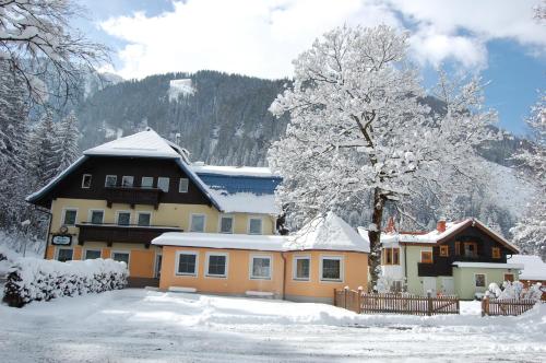 a house with snow on the ground in front of it at GRUBERS, Hotel Appartments Gastein in Bad Gastein
