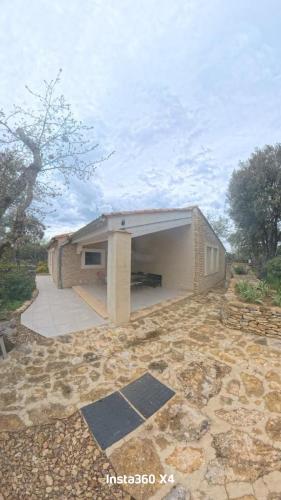 un petit bâtiment en briques avec un grand garage dans l'établissement Cabanon en Lubéron, à Bonnieux