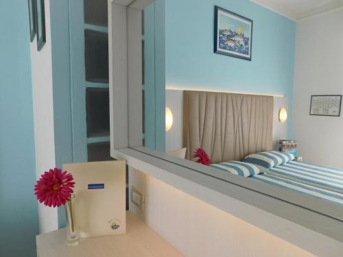 a bedroom with a large mirror and a bed at Hotel Oceano in Marina di Pietrasanta
