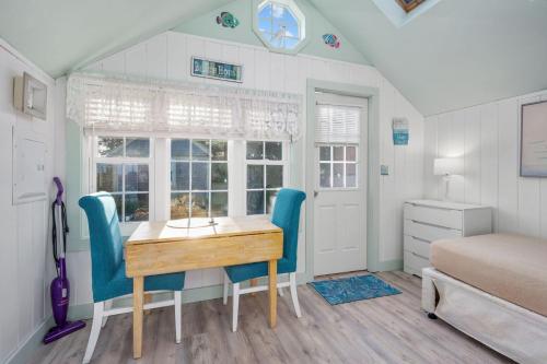 a dining room with a table and blue chairs at Seaside Cottages - Cottage 23 - SeaGills Rest in South Yarmouth