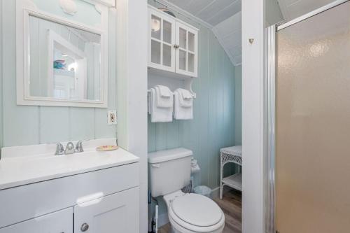 a white bathroom with a toilet and a sink at Seaside Cottages - Cottage 23 - SeaGills Rest in South Yarmouth