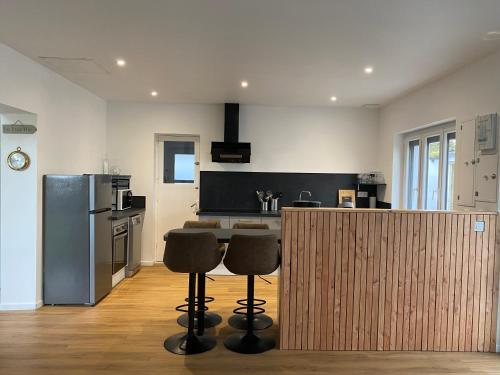 a kitchen with a counter with stools and a kitchen with a refrigerator at L'Echappée Bleue in Plougonvelin