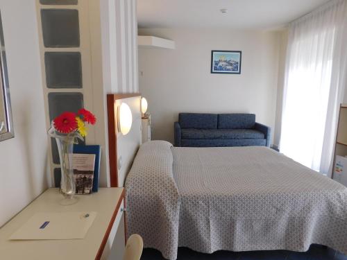 a bedroom with a bed and a vase of flowers on a table at Hotel Oceano in Marina di Pietrasanta
