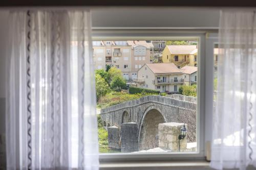 a window with a view of a stone bridge at Apartmani HM in Trebinje