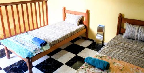 a bedroom with two beds and a checkered floor at Casa da Ana in Ananindeua