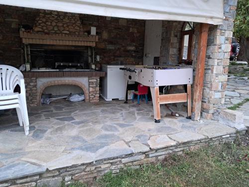 a stone patio with a table and a fireplace at Οικια κοντα μονοπατι των κενταυρων in Portariá