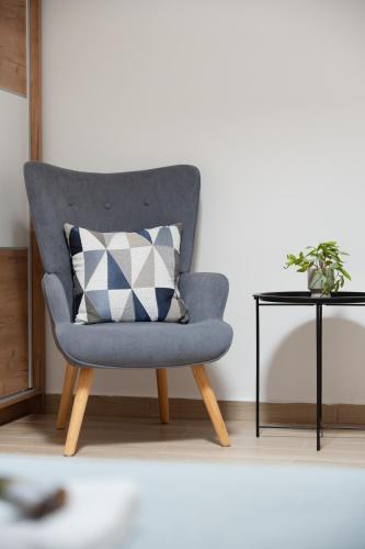 a blue chair with a pillow next to a table at Casa Moderna in Fourfourás