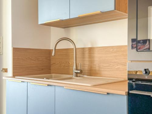 une cuisine avec un évier et un plan de travail en bois dans l'établissement Grand appartement lumineux avec vue imprenable sur la baie des Sables d'Olonne - 5 personnes, à Les Sables-dʼOlonne