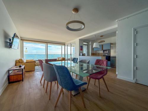 - une salle à manger et un salon avec une table et des chaises en verre dans l'établissement Grand appartement lumineux avec vue imprenable sur la baie des Sables d'Olonne - 5 personnes, à Les Sables-dʼOlonne