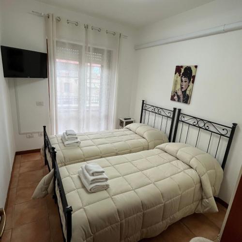 a bedroom with two beds and a flat screen tv at Appartamento Antonietta- in Santa Maria degli Angeli