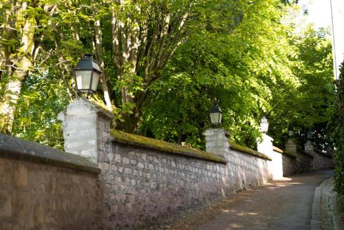 a stone wall with two lights on top of it at Divine Couture - Suite Vivienne in Carrières-sur-Seine