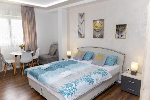 a bedroom with a bed and a table and chairs at Apartmani HM in Trebinje
