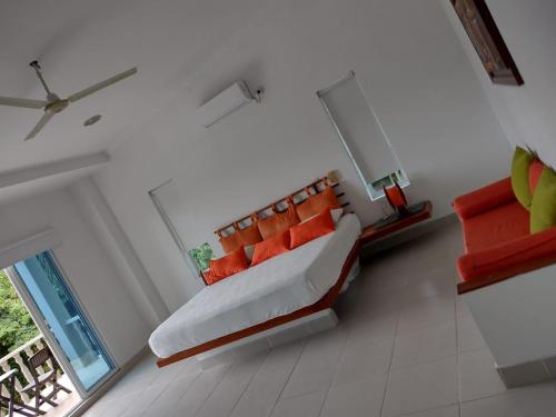 a living room with a couch with orange pillows at Casa Campestre en Condominio en Anapoima in Anapoima