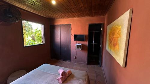 a bedroom with a bed with pink shoes on it at Hospedagem do Iago in Cabo Frio