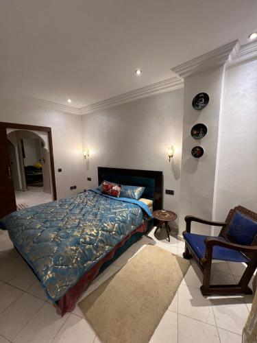 a bedroom with a bed and a chair at Entre Medina et Mer Duplex in Rabat