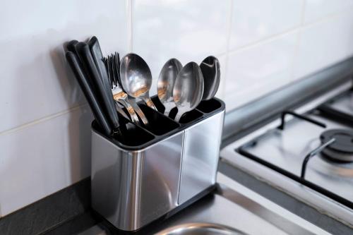 a metal container filled with utensils on a kitchen counter at Acqua Chiara Beachfront Home in Putzu Idu
