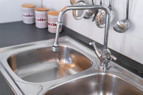 a sink in a kitchen with a faucet at Acqua Chiara Beachfront Home in Putzu Idu