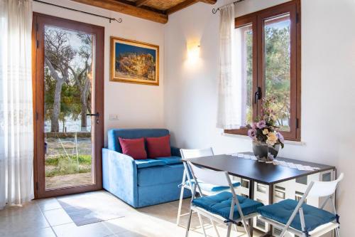 a dining room with a blue couch and a table and chairs at Acqua Chiara Beachfront Home in Putzu Idu