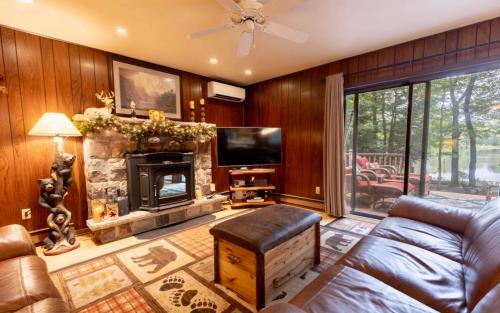 Una televisión o centro de entretenimiento en Lakehouse with Boats, MiniGolf, Sauna, HotTub, Swings and Playground!