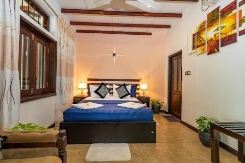 a bedroom with a blue bed in a room at The Villa By CMB Apartments in Negombo