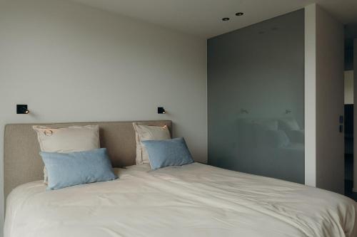 a bedroom with a large bed with two pillows at Au Porte Bonheur in Zwalm