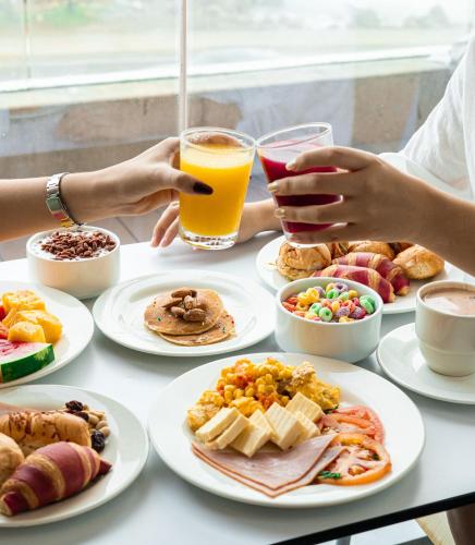 a table with plates of food and a glass of orange juice at ibis Cartagena Marbella in Cartagena de Indias