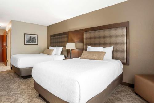 two beds in a hotel room with white sheets at Best Western Gardendale in Gardendale